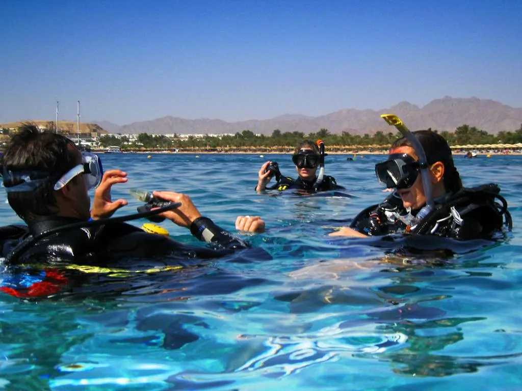 Three scuba divers practicing surface drills during an Advanced Open Water course in Sharm El Sheikh.
