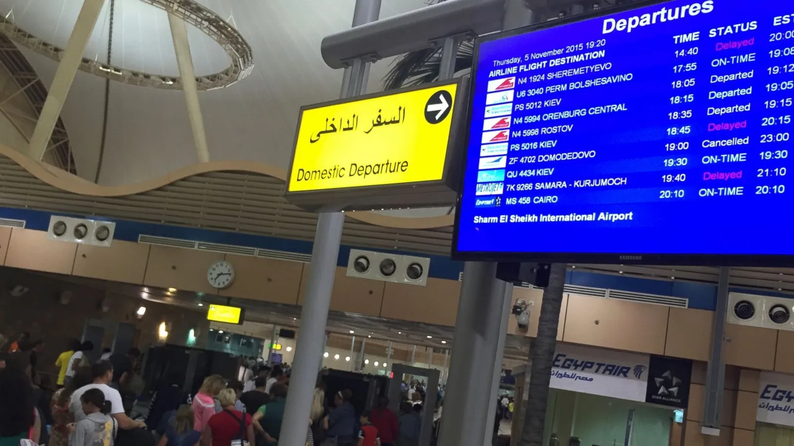 Sharm El Sheikh Airport departure board displaying delays near the domestic terminal.