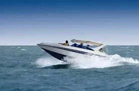 White and blue speed boat speeding across choppy Red Sea water, creating a large wake.