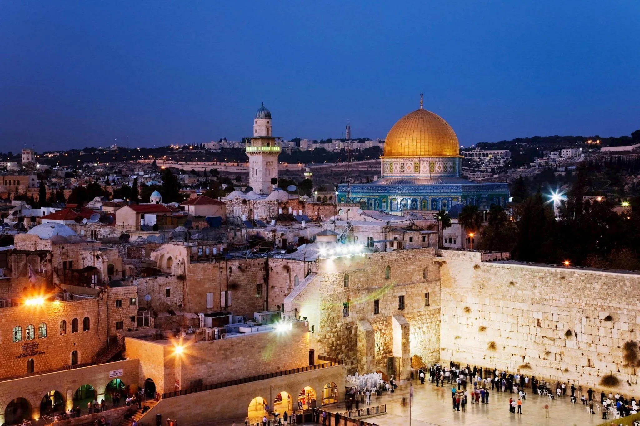Illuminated Western Wall and golden Dome of the Rock at twilight in Jerusalem.