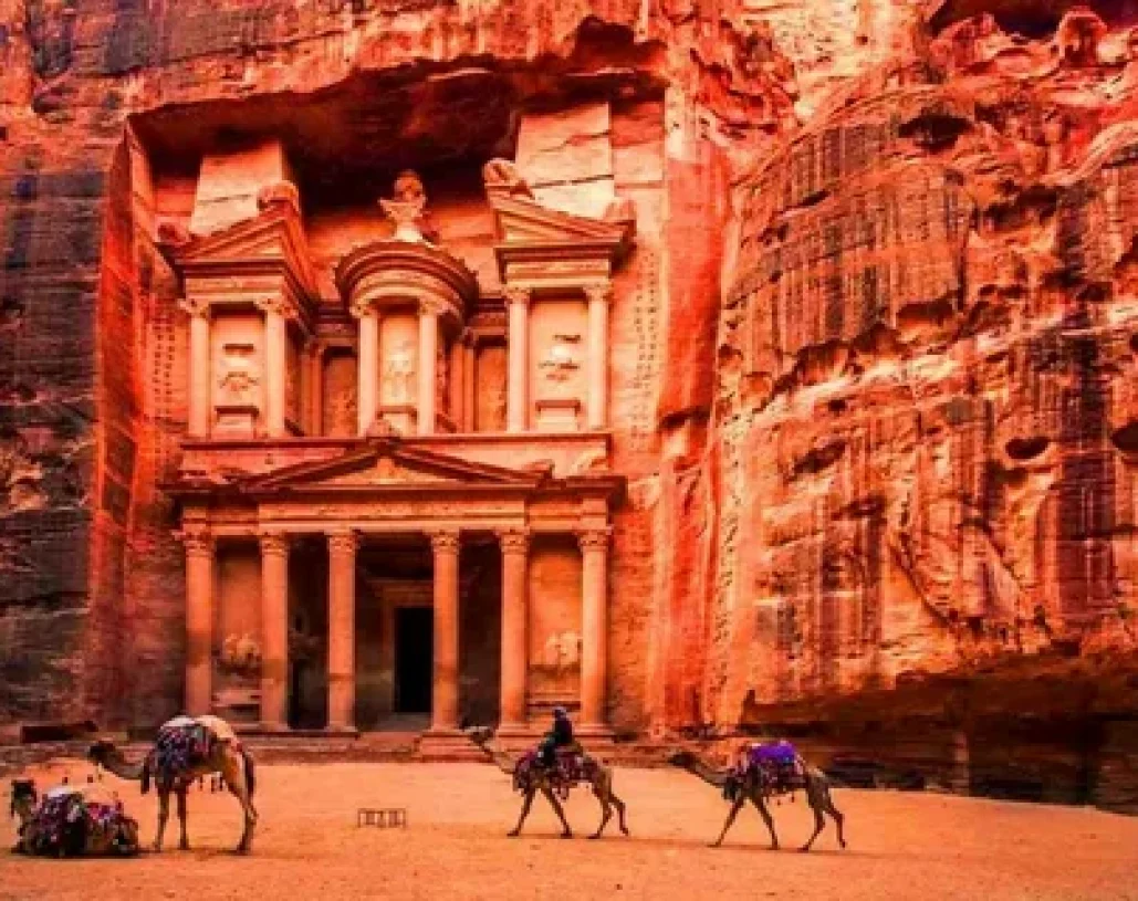 Al-Khazneh Treasury Petra Jordan sunset camels carved sandstone cliff.
